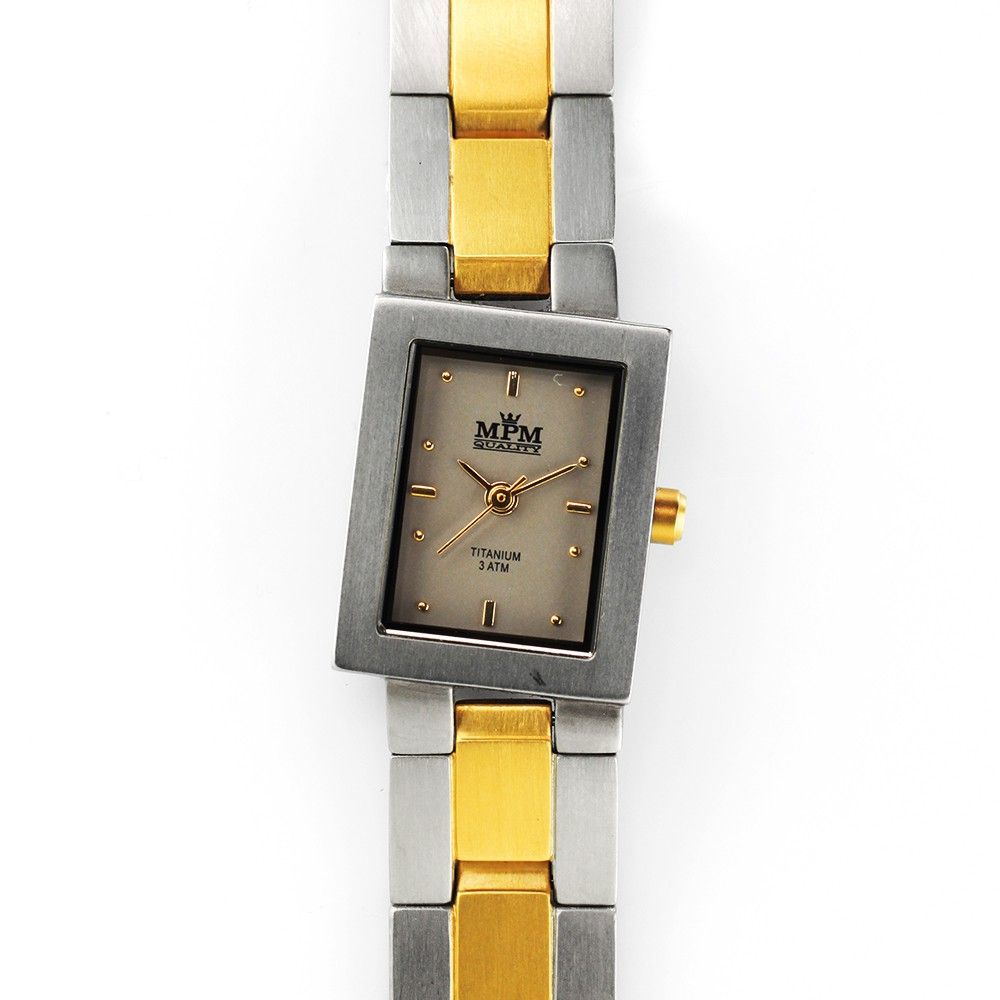 Minimalistický, ale i přesto velice elegantní model dámských titanových hodinek MPM Fancy s částečně pozlaceným titanovým řemínkem. Hranaté pouzdro hodinek je netradičně v náklonu, ? MPM Fancy - A